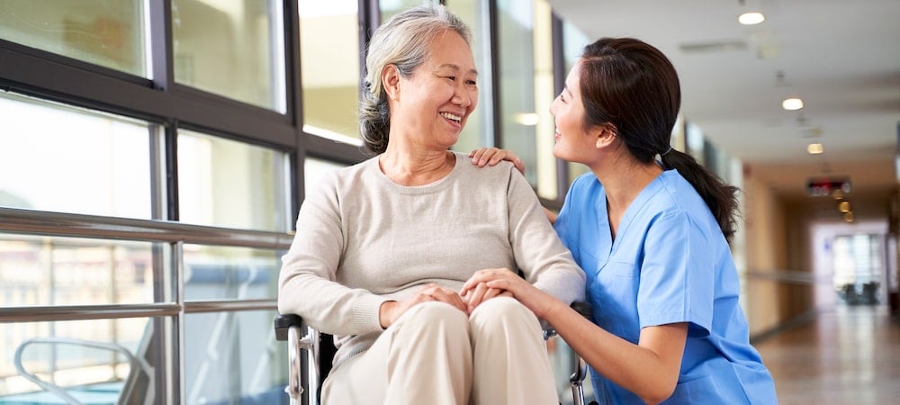 What Is a Life Care Plan in an Illinois Injury Claim? 1 A caregiver kneeling beside a smiling woman in a wheelchair